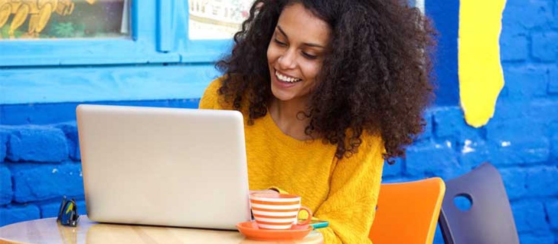 woman-on-laptop-cafe-colourful-background